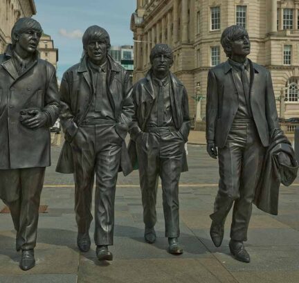 Iconic Beatles statues on Liverpool waterfront for scenic sightseeing and cultural exploration near luxury hotel.
